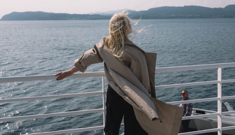 A woman with a chronic condition is standing on the deck of a boat, seeking care and education.