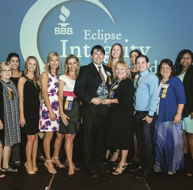 A group of people posing for a photo with the fertility treatment infinity award.