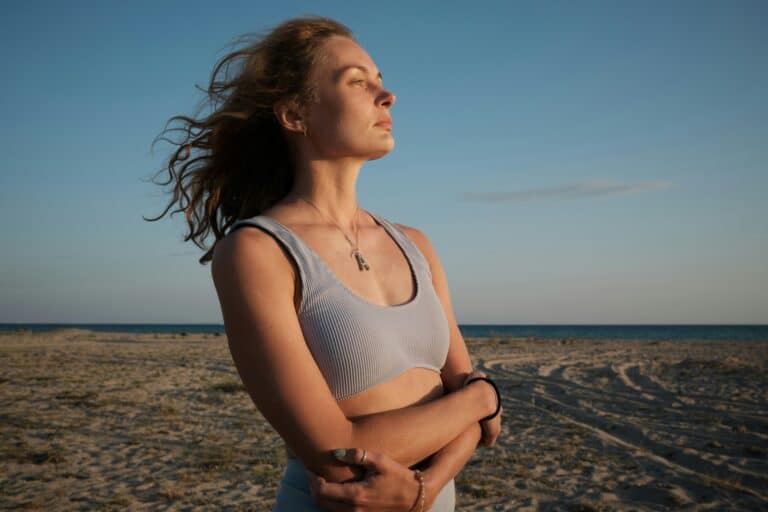 Woman standing on a beach, facing the sun, considering fertility preservation before cancer treatment