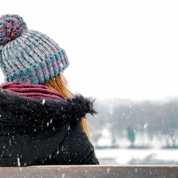 woman in a hat on a bench in the snow