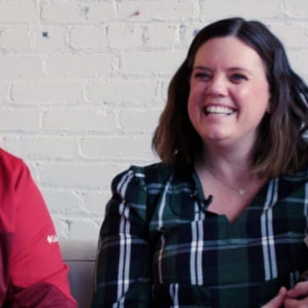 A couple practicing family planning hold their baby in their arms on a cozy couch.