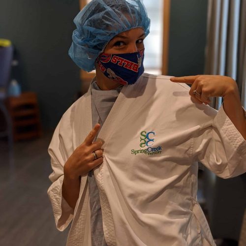 A woman in a lab coat pointing at something related to fertility treatment.