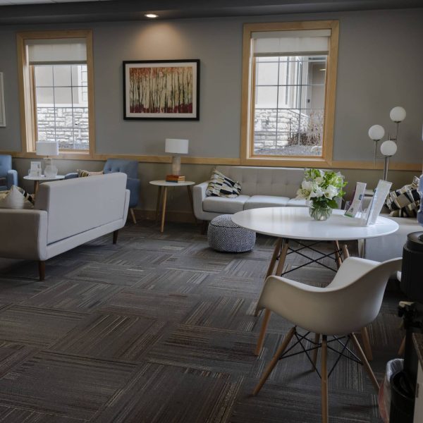 A room with a table, chairs, and a refrigerator for IVF treatment.