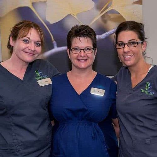 Three women in scrubs posing for a photo during fertility treatment.