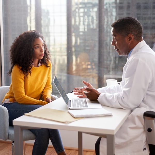 A doctor discussing fertility treatment options with a woman at a desk.