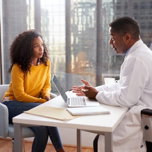 A doctor discussing fertility treatment options with a woman at a desk.