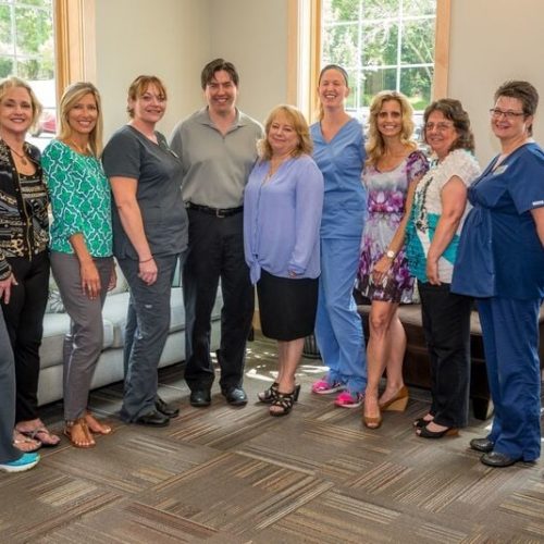 + A group of people posing for a picture in a dental office.